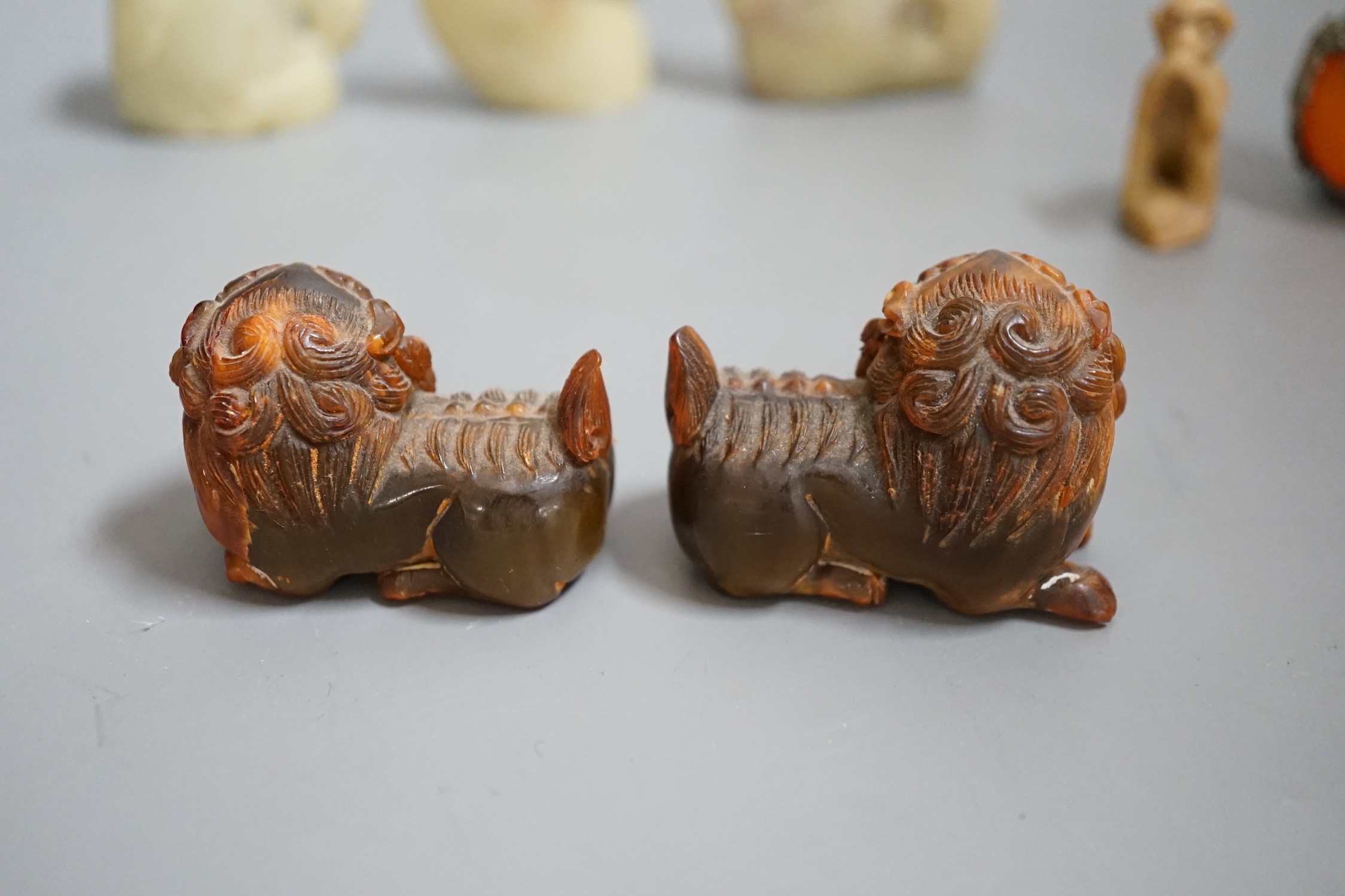 Two carved horn Buddhistic lions, four soapstone carvings and a pair of Chinese nickel and amber-glass ornaments, horn lions 5cm wide